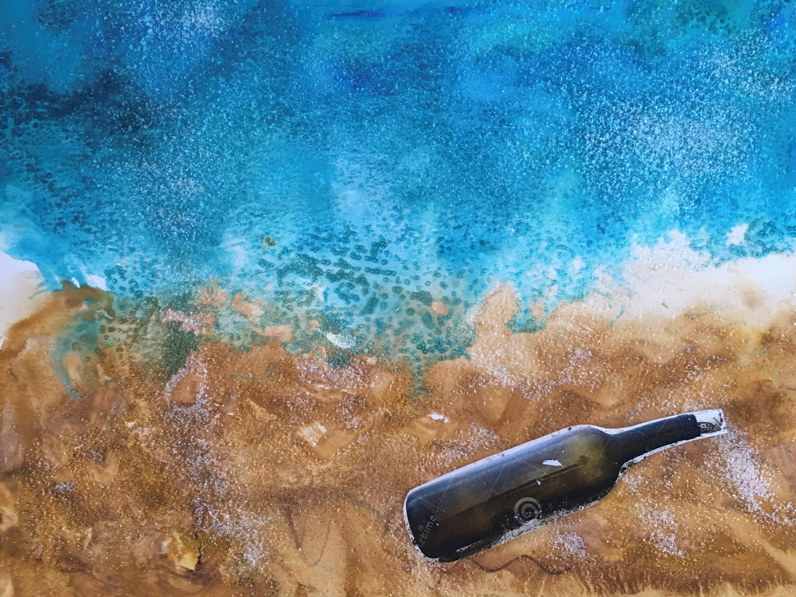 A mixed media artwork that has a textured background that resembles water meeting a shore. A long bottle is cutout and collaged in the lower right as if it has washed to shore.