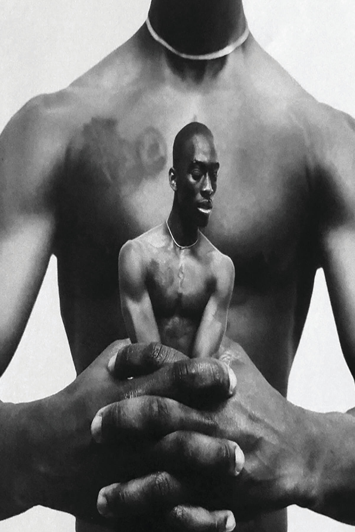 A black and white photo collage. The bare torso of a black man extends his arms forward and clenches his hands together. Caught within those hands is a smaller image of the shirtless black man, his arms constrained by the large hands within which he's held.